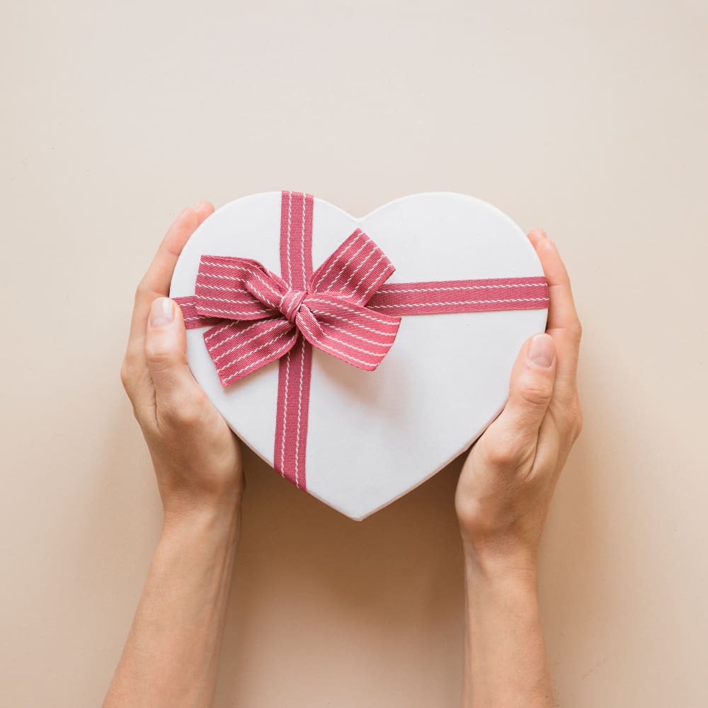 person holding gift box heart shape Adscraft.in An Amazing Gift For Lovely People